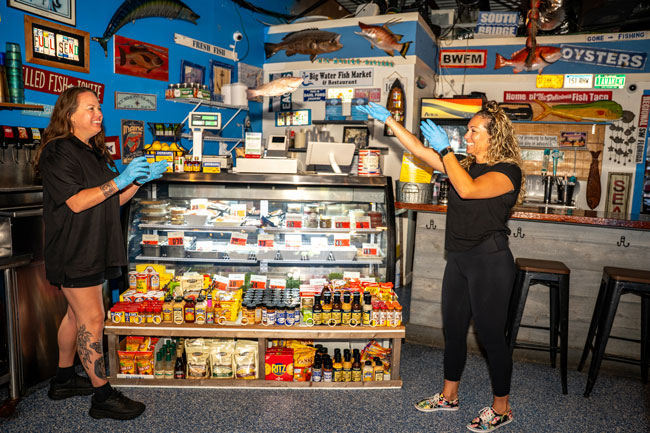 The retail side of the market: a refrigerated fish case, shelves of sauces and spices, and staff behind the counter