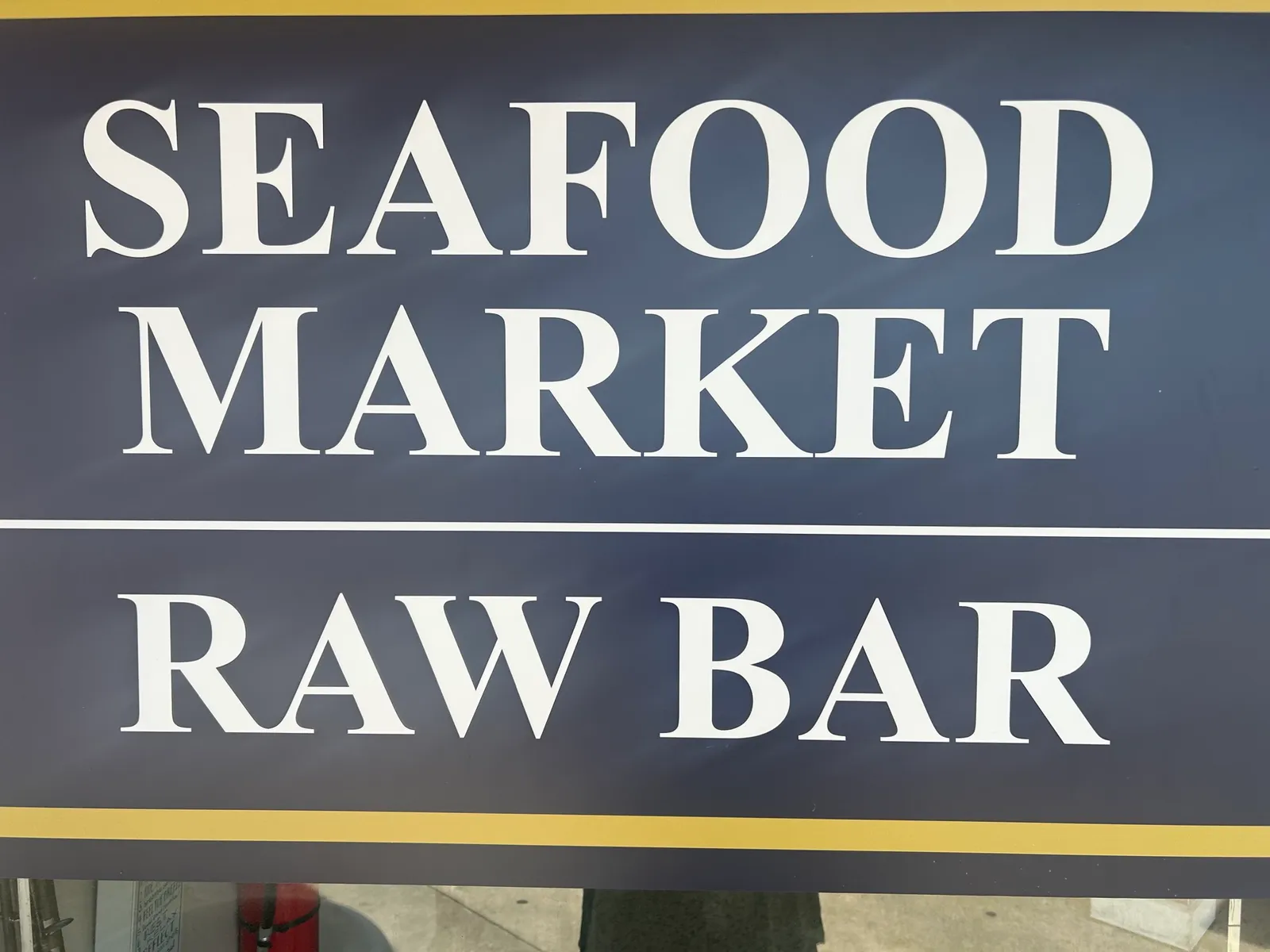 The navy Seafood Market and Raw Bar sign inside the shop